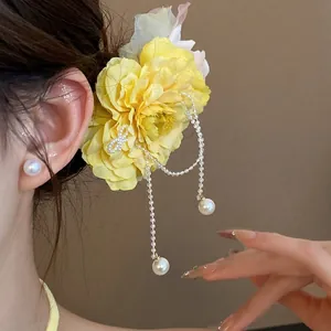 Elegant yellow fabric flower hair clip with dangling pearl tassels for a sweet vacation look