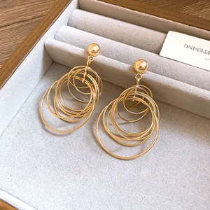 Close-up of elegant golden multi-layered geometric hoop earrings in a velvet jewelry box