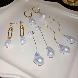 Detail of four unique irregular baroque pearl earrings displayed on a cream tray