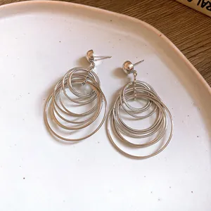 Detail view of silver geometric earrings with interlocking circles on a plate