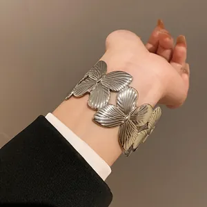 Detailed close-up showing textured silver butterfly pattern of fashion cuff bracelet