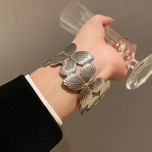 Close-up macro detail of a fashionable silver metallic butterfly bracelet on wrist