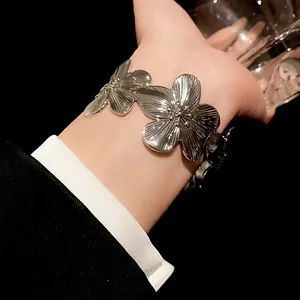 Close-up of a chic metallic silver flower open cuff bracelet with textured petals