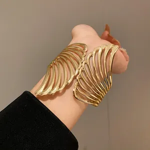 Close-up macro detail of the elegant gold-plated metal wing open cuff bracelet