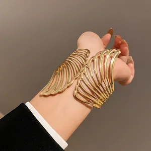 Close-up of elegant gold leaf-inspired open cuff bracelet worn on wrist