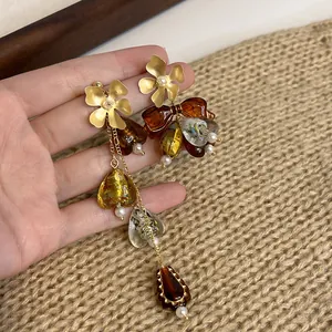 Macro view of unique asymmetric flower and bow earrings with retro Maillard style details