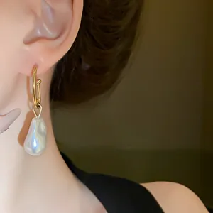 Exquisite detail shot of a French-style baroque pearl earring with a sleek gold hook