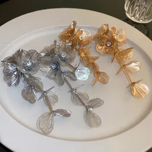 Elegant silver and gold oversized flower tassel earrings with sparkling rhinestone centers