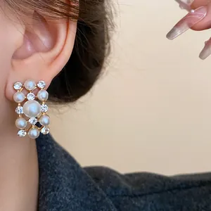 Close-up of vintage geometric earrings with elegant pearls and sparkling rhinestones