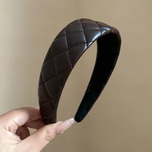 Detailed view of brown quilted leather padded headband with high cranial top effect