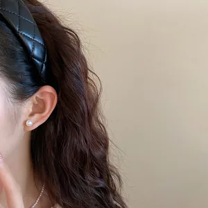 Close-up of a black quilted leather headband on model for high cranial top effect