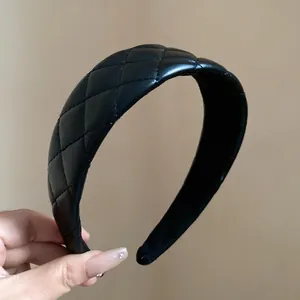 Detail view of black quilted leather headband showing fine stitching and padded design.