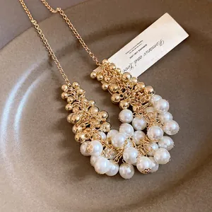 Detailed macro view of French vintage pearl and gold bead cluster tassel necklace