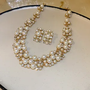 French vintage pearl and rhinestone necklace and earring set on a ceramic plate