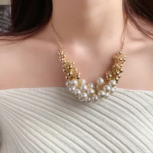 Close-up of French vintage pearl tassel necklace with gold beads on model