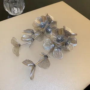 Close-up of silver-tone mesh flower tassel earrings with sparkling rhinestones