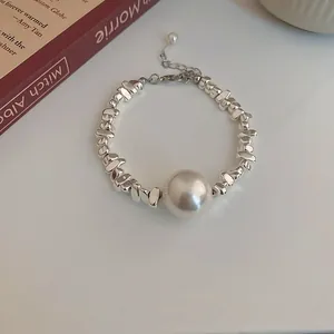 Close-up of elegant pearl bracelet with irregular silver-tone metallic beads