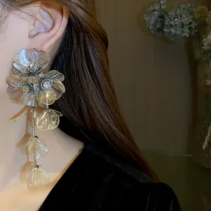 Close-up of elegant silver needle flower tassel earrings with sparkling rhinestone centers