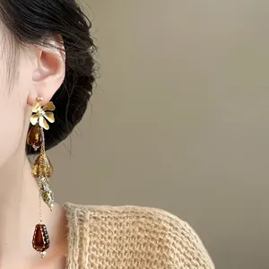 Detailed close-up view of vintage asymmetric flower drop earrings worn by a model.