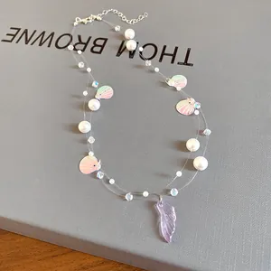 Close-up detail of a double-strand pearl necklace with iridescent shell and fish tail