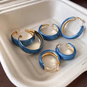 Elegant set of marbled Klein blue hoop earrings with polished gold-tone hardware