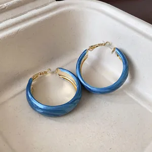 Close-up detail showing the Klein blue marbled texture on these silver hoop earrings