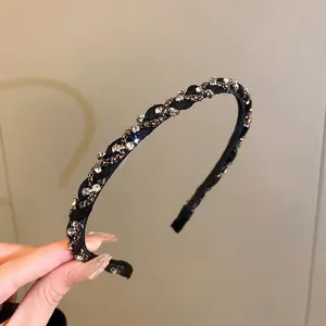 Elegant black braided headband with sparkling rhinestones for a sophisticated look.