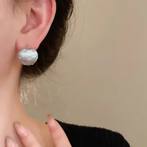 Close-up of a premium brushed silver stud earring featuring sparkling rhinestone stars