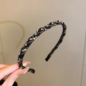 Macro view of elegant black braided headband with sparkling clear crystal rhinestones