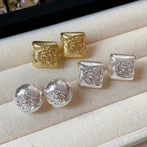 Vue détaillée de boucles d'oreilles géométriques plaquées or 18 carats avec texture martelée