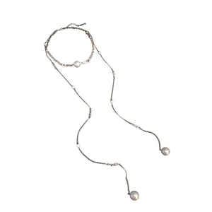 Elegante collana lunga con nappe e perle bianche su una delicata catena color argento