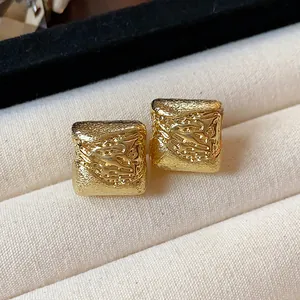 Gros plan de boucles d'oreilles clips carrées plaquées or 18k à texture martelée.
