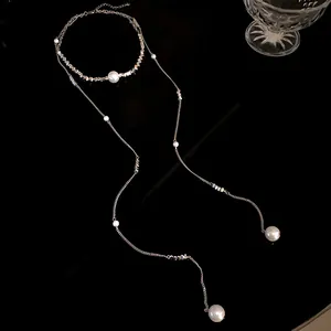 Vista dettagliata di un'elegante collana lunga con nappe di perle e design minimalista