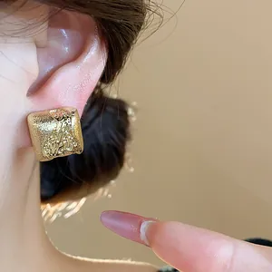 Détail des boucles d'oreilles clips carrées géométriques plaquées or 18 carats texturées