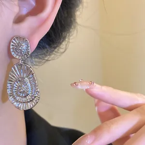 Detailed close-up showing the unique radial spiral texture of silver oval drop earrings