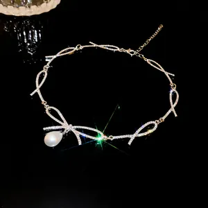 Detailed view of the rhinestone bow choker necklace featuring an elegant teardrop pearl drop