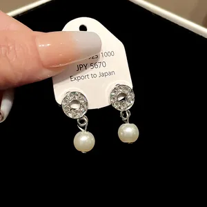 Elegant silver stud earrings with sparkling pavé crystals and white pearls.
