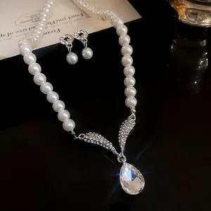 Close-up of elegant French style pearl necklace set with rhinestone teardrop pendant.
