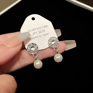 Detailed close-up view of elegant silver pearl earrings with sparkling rhinestone circles