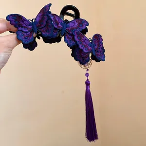 Detail of purple embroidered butterfly hair claw clip with elegant long tassel