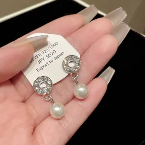 Close-up of elegant 925 silver earrings featuring crystals and round white pearls