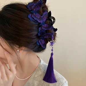 Detailed view of an elegant embroidered purple butterfly hair clip with a long hanging tassel
