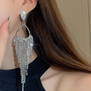 Close-up of sparkling rhinestone waterdrop tassel earring worn by a model