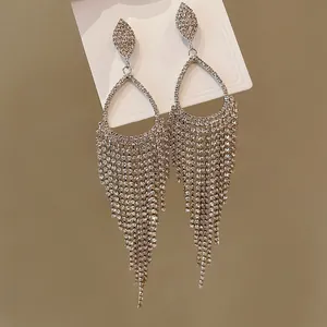 Detailed macro view of sparkling rhinestone waterdrop tassel earrings with fringe design