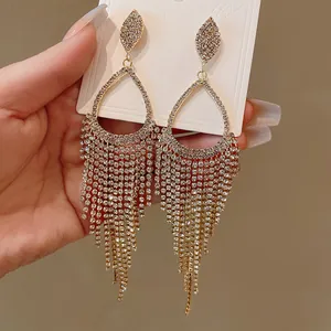 Close-up of elegant silver rhinestone water drop earrings with sparkling tassel fringe.