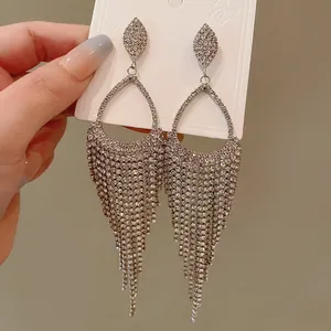 Detailed view of elegant rhinestone teardrop tassel earrings on a white display card.