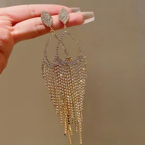 Detailed close-up of sparkling rhinestone water drop tassel earrings with vintage gold finish
