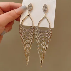 Close-up of elegant sparkling rhinestone teardrop tassel earrings featuring delicate silver needles