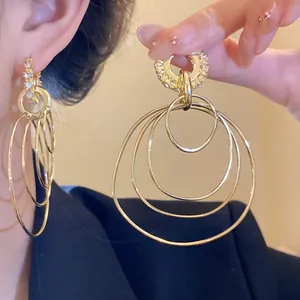 Close-up of golden multi-layered circular earrings with shimmering rhinestone details