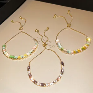 Detailed close-up of three colorful zircon adjustable bracelets with gold sliding clasps